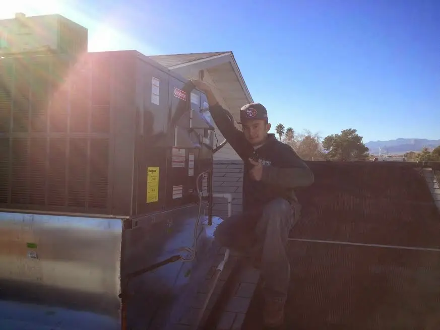 HVAC technician performing AC Tune-Up on a rooftop unit in Clarksburg